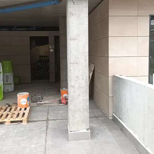 Terraza exterior de un edificio de viviendas con las paredes desgastadas.