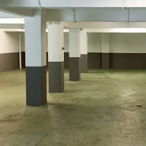 Garaje con parcelas para coches con las paredes, columnas y suelos recién pintados y reformados.