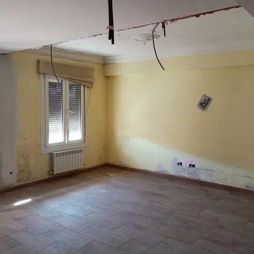 Habitación con paredes en proceso de obra y con ventana exterior.