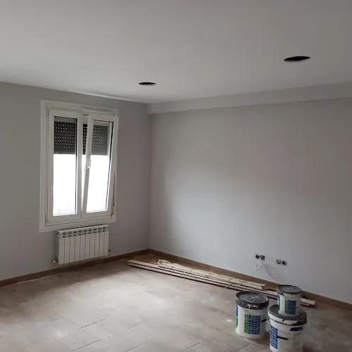 Habitación con paredes recién pintadas se blanco y con una ventada al exterior de la vivienda.