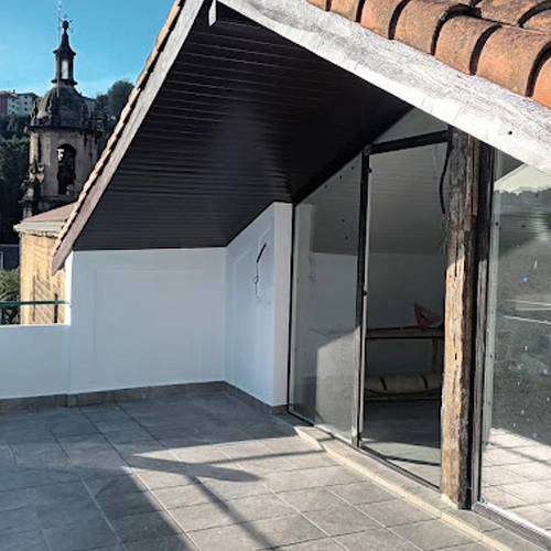 Terraza exterior de el ático de una casa donde se están haciendo reformas de la parte de dentro del piso