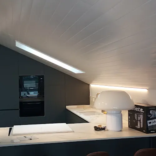 Cocina de un ático recién reformado con una lámpara de mesilla moderna